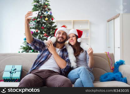 Young pair taking selfies during christmas