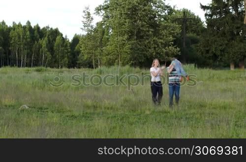 Young parents and their little son walking in the wood together. Father spinning his little child. Outdoor family activities