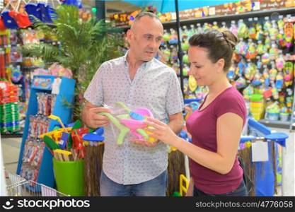 young parents buying baby toy