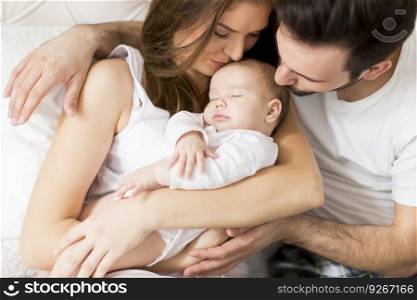 Young parents enjoying time spent with their adorable newborn daughter