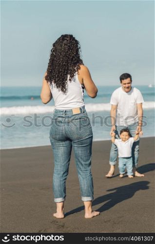 young parents playing with baby beach