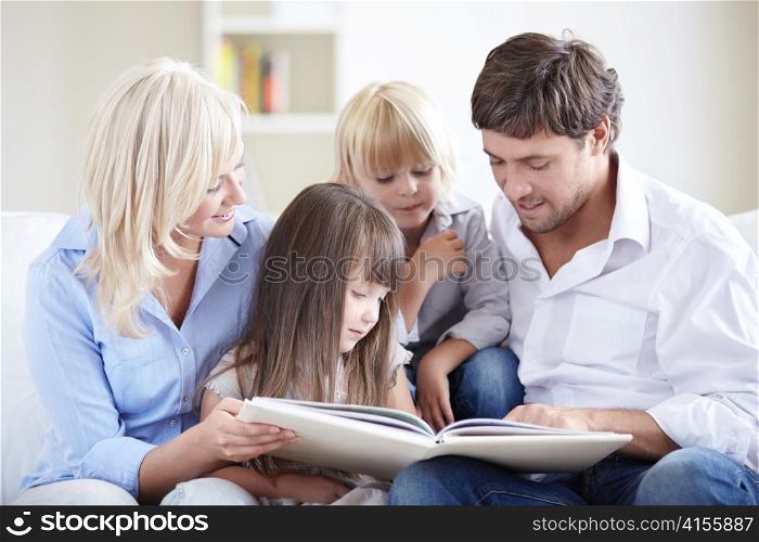 Young parents reading a book for young children