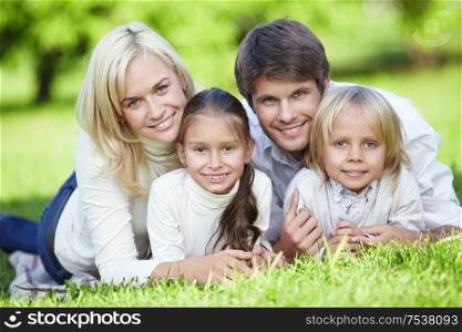 Young parents with children on the grass