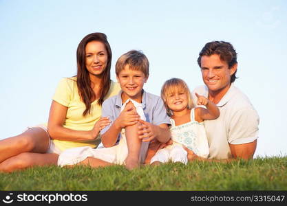 Young parents, with children, posing on a field