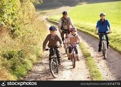 Young parents with children ride bikes in park