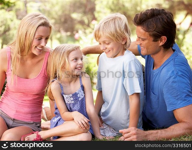 Young parents with children talking in a park