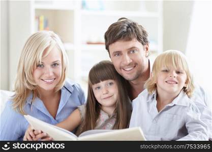 Young parents with children while reading a book