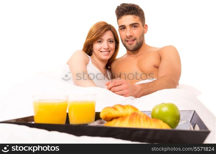Young passionate couple having breakfast in bed