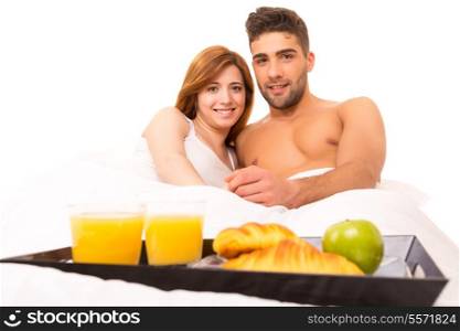 Young passionate couple having breakfast in bed