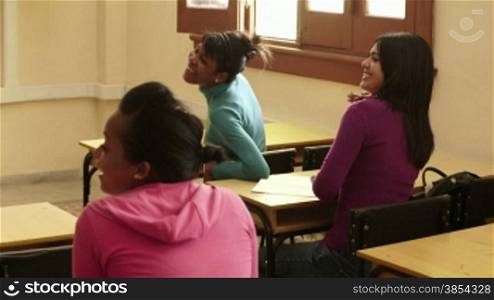 Young people and education, group of female friends talking and laughing in university class