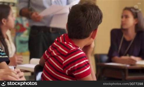 Young people and education. Group of hispanic students in class at school during lesson. Sad male student depressed for bad grades on test, unhappy boy with papers