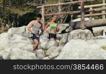 Young people and sport activities, man and woman running on mountain path. Slow motion. Part 2 of 4