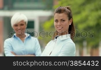 Young people and success, portrait of two young business women smiling and looking at camera