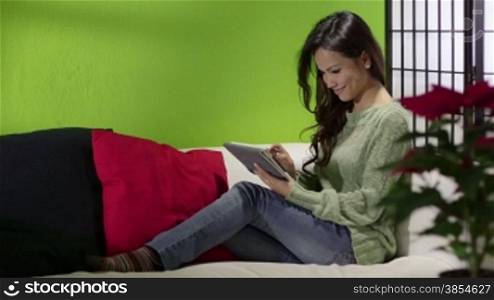 Young people and technology, Asian girl typing on digital tablet, pretty female student using computer, sitting on sofa at home. 14of16
