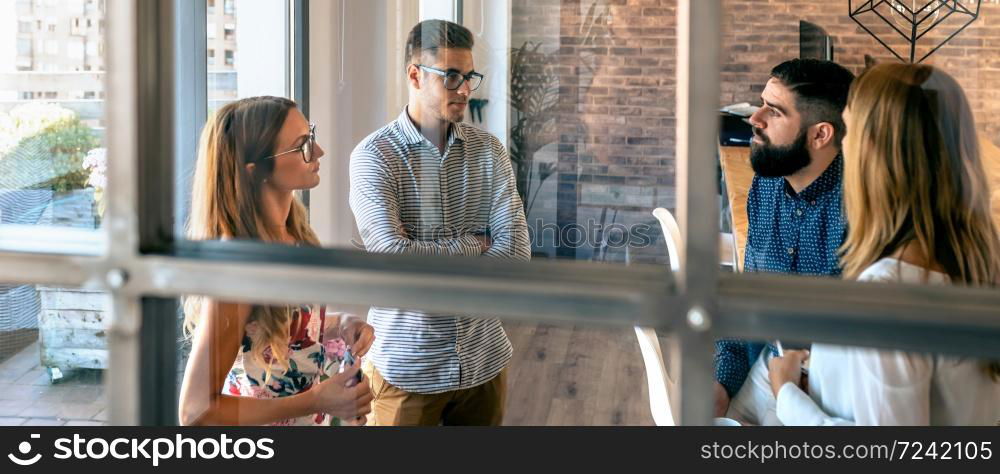 Young people at a business meeting standing in the office. People at a business meeting in the office