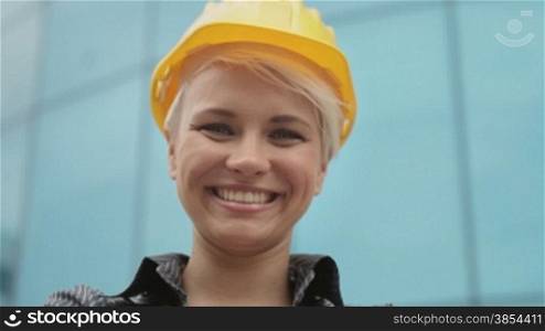 Young people at construction site, portrait of female architect with helmet smiling at camera. Sequence