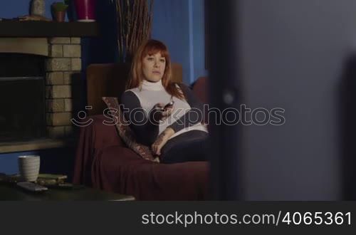 Young people at home, lifestyle and relax, happy caucasian woman lying on sofa, girl watching television, tv channel surfing with remote control. 8 of 16