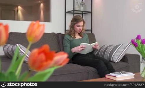 Young people at home, woman lifestyle, happy college female student studying for school homework with book and notebook computer, laptop pc. Education and girl on sofa