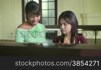 Young people at school, female students studying and doing homework in college library