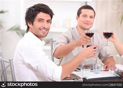 young people clinking glasses with red wine