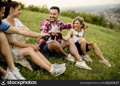 Young people drinking and having fun on a trip in nature on mountain