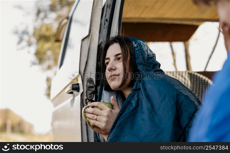 young people drinking coffee inside their van
