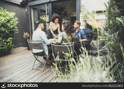 Young people enjoy the food and drink and have great fun outdoors in backyard