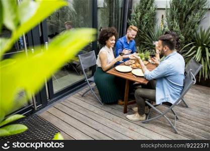 Young people enjoy the food and drink and have great fun outdoors in backyard