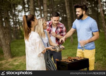 Young people enjoying barbecue party in the nature