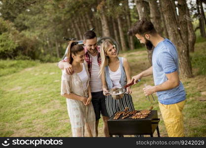 Young people enjoying barbecue party in the nature