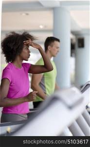 young people exercisinng a cardio on treadmill running chine in modern gym