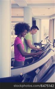 young people exercisinng a cardio on treadmill running chine in modern gym. people exercisinng a cardio on treadmill in gym