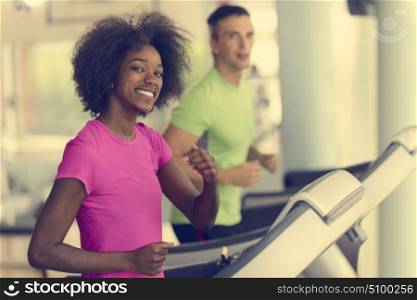 young people exercisinng a cardio on treadmill running machine in modern gym