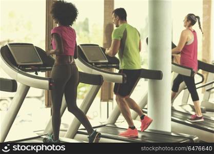 young people exercisinng a cardio on treadmill running machine in modern gym. people exercisinng a cardio on treadmill