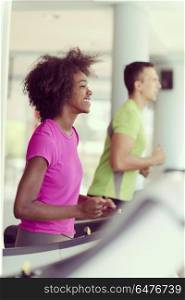 young people exercisinng a cardio on treadmill running machine in modern gym. people exercisinng a cardio on treadmill