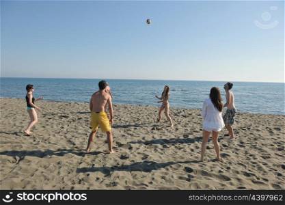 young people group have fun and play beach volleyball at sunny summer day