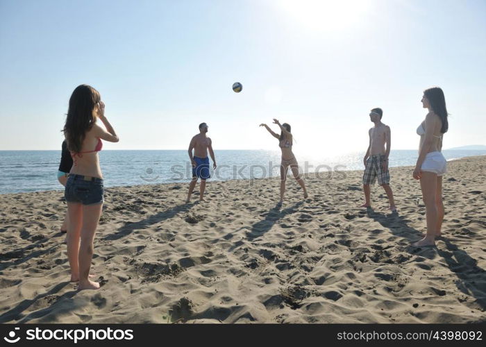 young people group have fun and play beach volleyball at sunny summer day