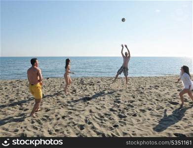 young people group have fun and play beach volleyball at sunny summer day