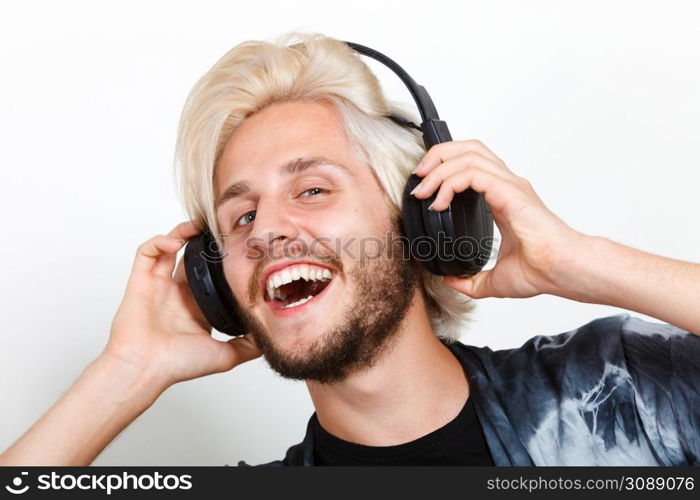 Young people, happiness and leisure concept. Passionate music lover joyful stylish guy with headphones listening music, relaxing enjyoing. cool guy having fun listens to music in headphones