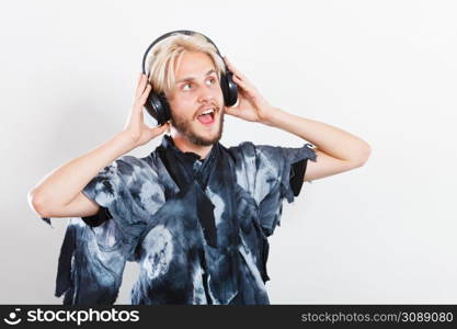 Young people, happiness and leisure concept. Passionate music lover joyful stylish guy with headphones listening music, relaxing enjyoing. cool guy having fun listens to music in headphones