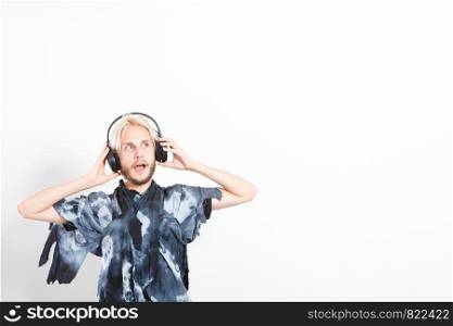 Young people, happiness and leisure concept. Passionate music lover joyful stylish guy with headphones listening music, relaxing enjyoing, copy space. cool guy having fun listens to music in headphones