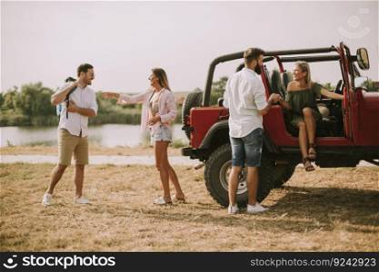 Young people having fun by cabriiolet car and  river