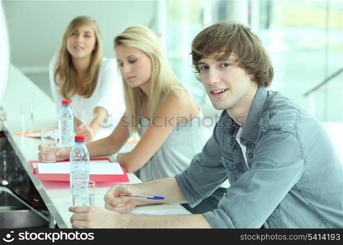 Young people in a bar with coursework and bottles of water