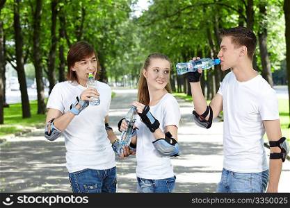 Young people in equipment in park drink water