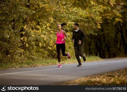 Young people jogging and exercising in autumn nature enviroment