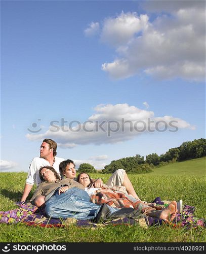 young people lying in field