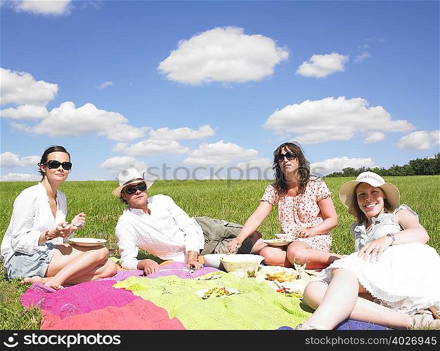 young people on blanket in field