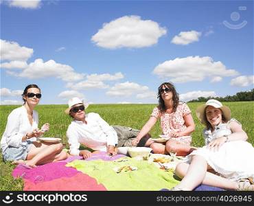 young people on blanket in field