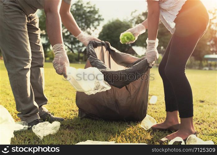young people picking up garbage plastic for cleaning at park
