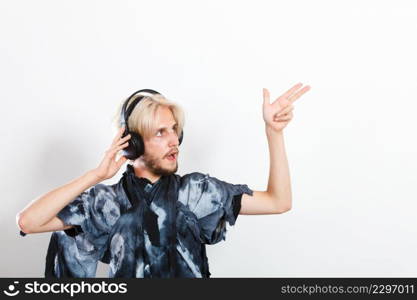 Young people, relax and passion concept. Passionate music lover stylish guy with headphones listening music, relaxing enjyoing, studio shot on white. cool guy having fun listens to music in headphones